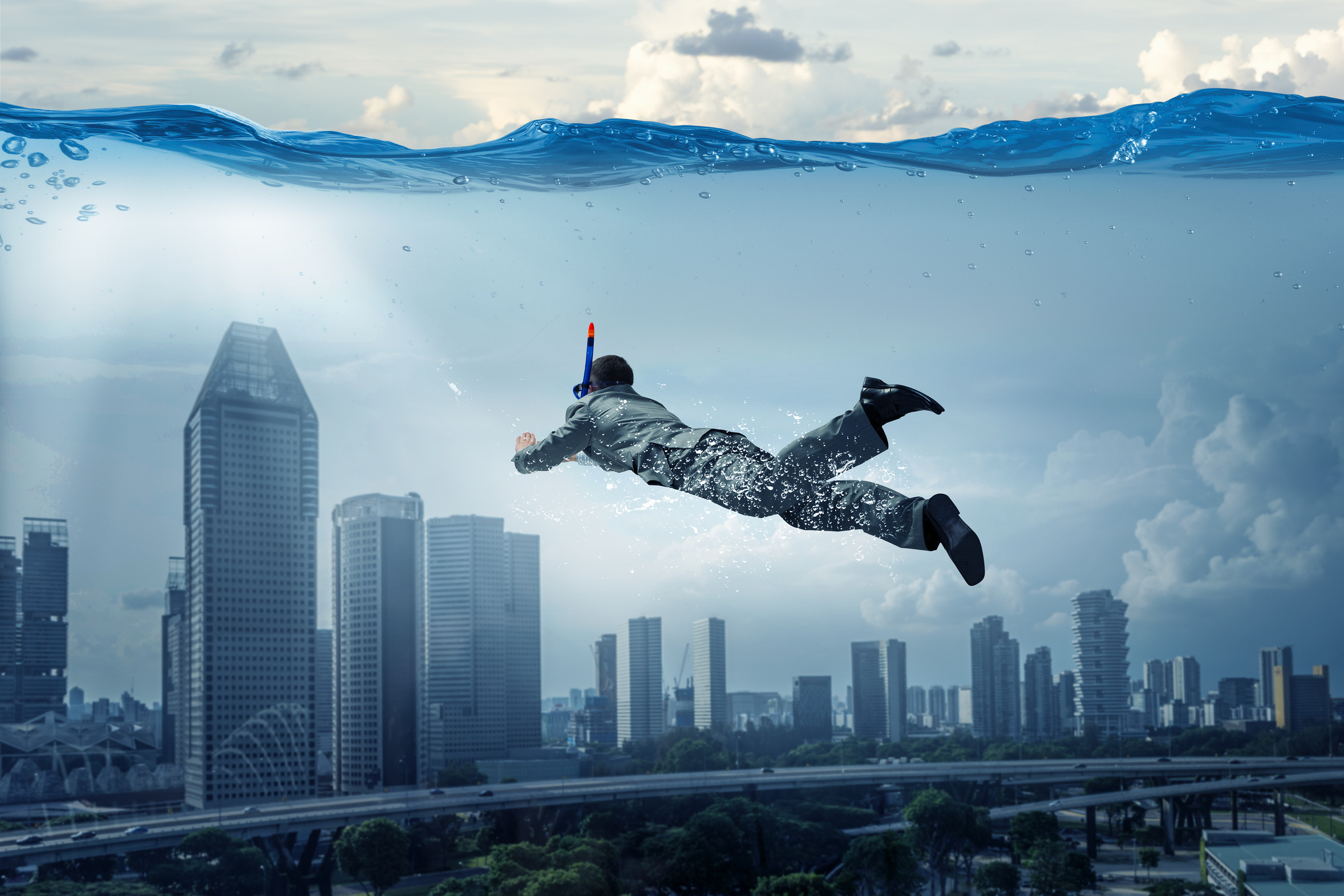 Ein Mann taucht durch eine überschwemmte Stadt